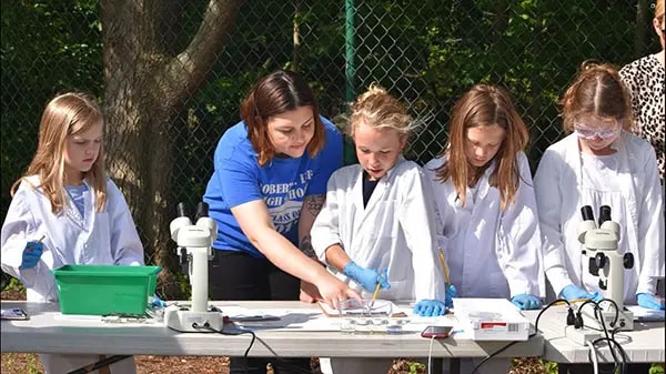 A teacher leads students in a leaf pack project.